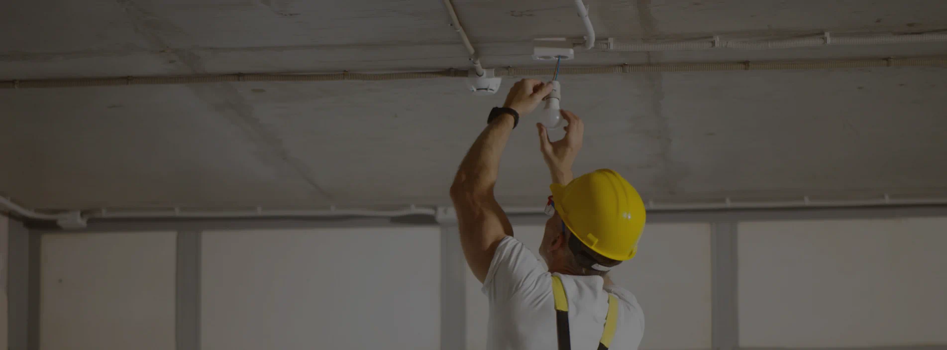 technician installing new electrical lighting connection at a newly built house